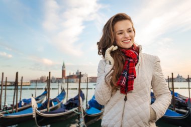 Dreamy woman traveler standing on embankment in Venice, Italy
