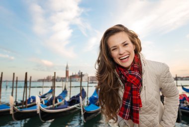 Portrait of happy woman traveler on embankment in Venice, Italy