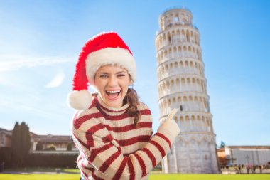 Noel Baba şapkası Pisa tur eğilerek işaret içinde gülümseyen kadın