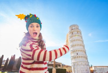 Pisa tur eğilerek destekleyen Noel ağacı şapkalı kadın