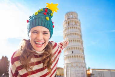 Pisa tur eğilerek işaret Noel ağacı şapkalı kadın