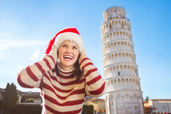 Mujer en Santa sombrero mirando hacia arriba en frente de la gira inclinada de Pisa — Foto de Stock