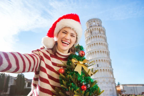 Женщина с рождественской елкой делает селфи возле Тура наклона — стоковое фото