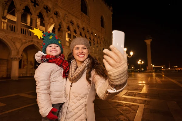Μητέρα με παιδί λαμβάνοντας selfie στην πλατεία του Αγίου Μάρκου, βράδυ — Φωτογραφία Αρχείου