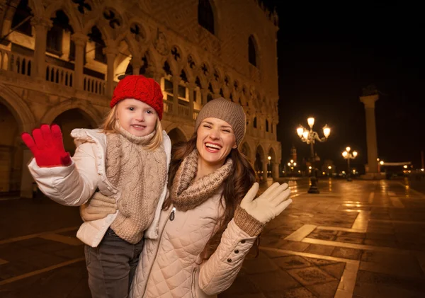 Мать и ребенок размахивают руками на площади Сан-Марко вечером — стоковое фото