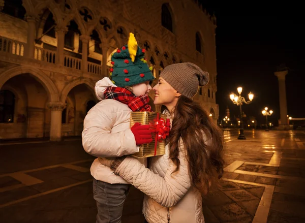 Happy mother hugging child with Christmas gift box in Venice — Stock Photo, Image