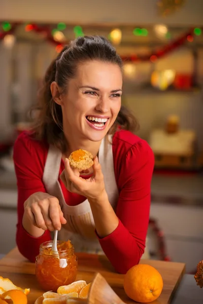 Femme au foyer dégustation de confiture d'orange dans la cuisine de Noël — Photo