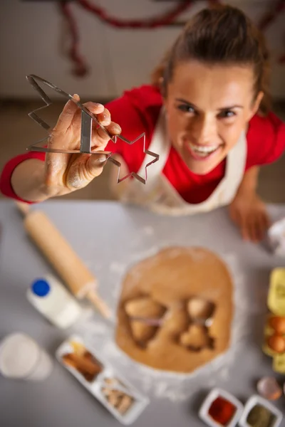 Dona de casa mostrando cortador de biscoitos de Natal na cozinha. Fechar. — Fotografia de Stock