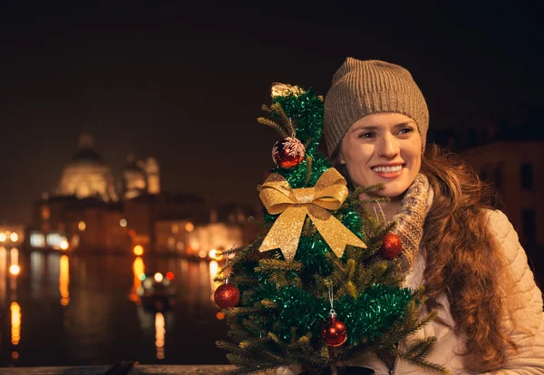 Glad kvinna med julgran står på en bro i Venedig — Stockfoto