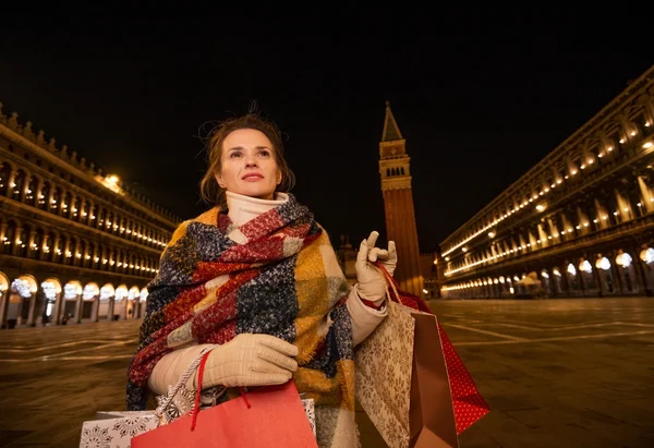 Современная женщина с сумками для покупок на площади Сан-Марко вечером — стоковое фото