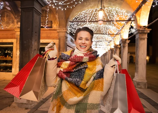 Kvinna med shoppingkassar står under jul ljus, Venedig — Stockfoto