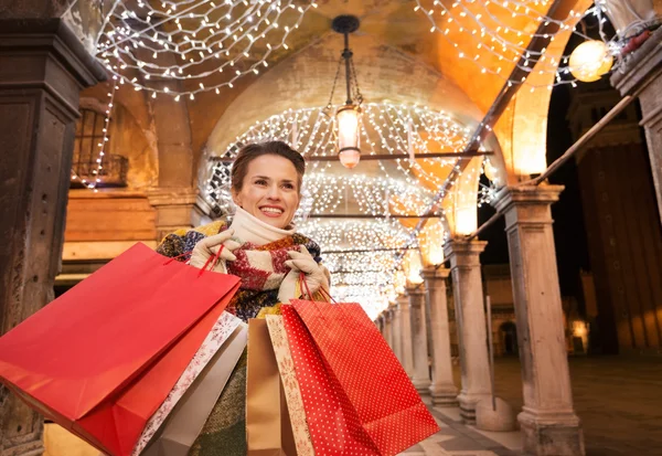 Mujer feliz con bolsas de compras mirando a la distancia en Venecia —  Fotos de Stock