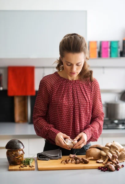 Frau schaut in Küche und bereitet Knoblauch und Pilze zu — Stockfoto