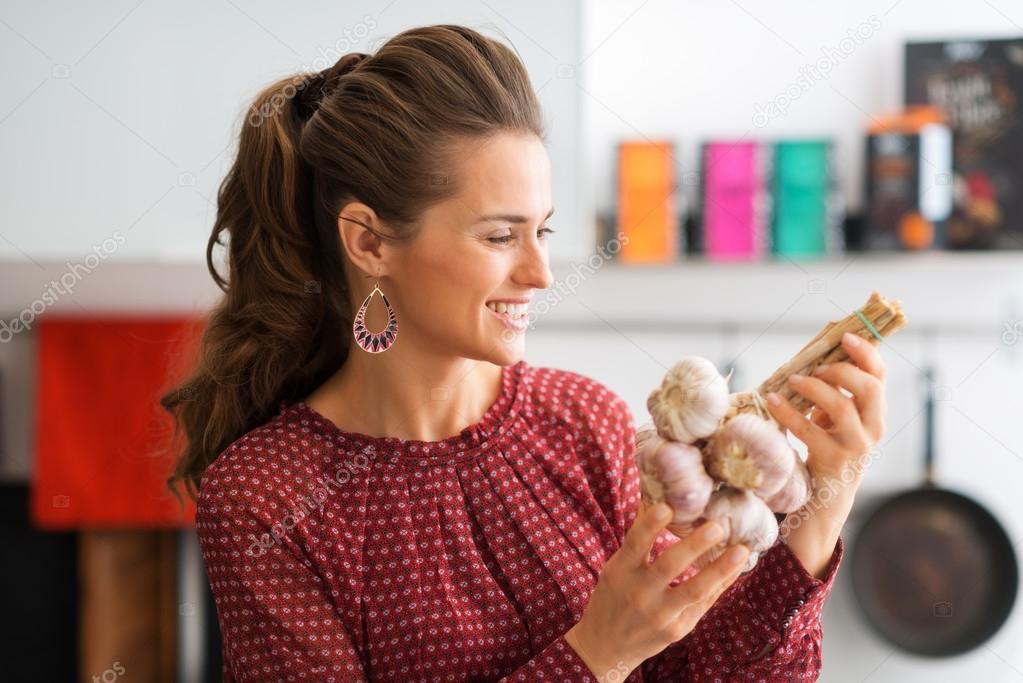 Closeup of woman holding up bunch of garlic
