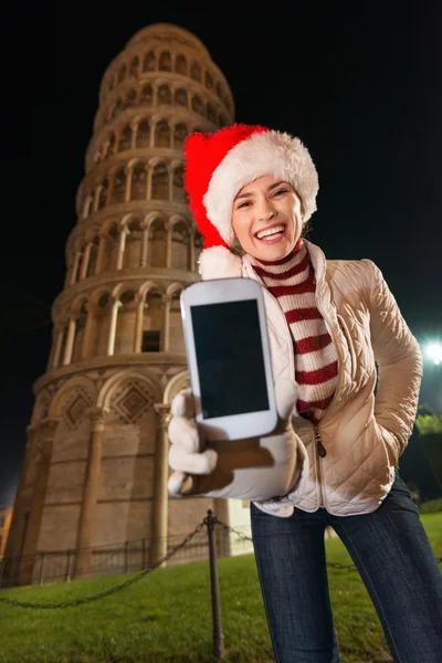 Kobieta w kapeluszu Santa Wyświetlono telefonu komórkowego w pobliżu Krzywa Wieża, Pisa — Zdjęcie stockowe