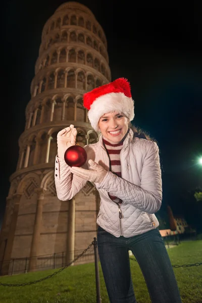 Mujer feliz mostrando la bola de Navidad cerca de la Torre Inclinada de Pisa — Foto de Stock