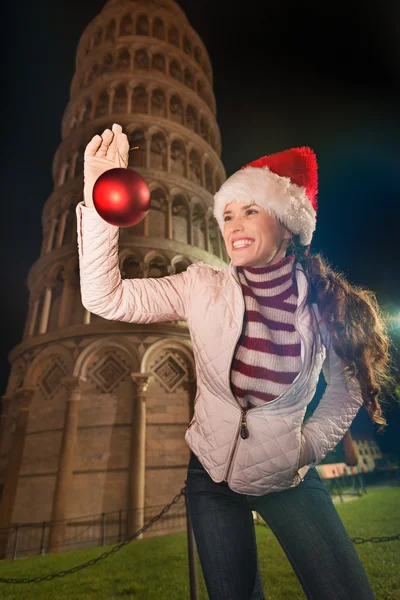 Mujer en sombrero de Santa con bola de Navidad cerca de la Torre Inclinada, Pisa — Foto de Stock