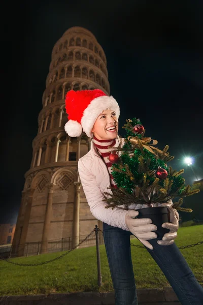 Γυναίκα με καπέλο Santa με χριστουγεννιάτικο δέντρο κοντά σε Κεκλιμένος Πύργος, Πίζα — Φωτογραφία Αρχείου
