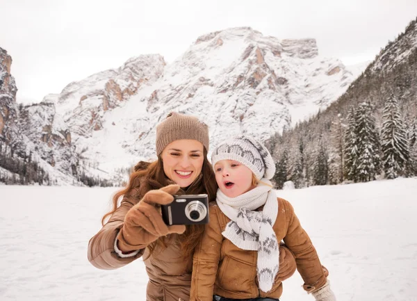 Madre e hijo sorprendido revisando fotos en invierno al aire libre — Foto de Stock