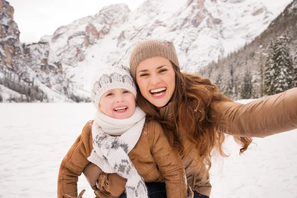 Mãe e criança tomando selfie entre montanhas cobertas de neve — Fotografia de Stock