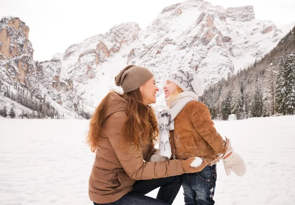 Mère jouant avec l'enfant à l'extérieur parmi les montagnes enneigées — Photo