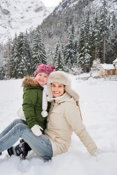 Mãe feliz e criança ao ar livre na frente de montanhas nevadas — Fotografia de Stock