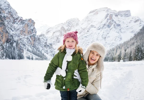 Sonriente madre e hijo al aire libre frente a las montañas nevadas — Foto de Stock