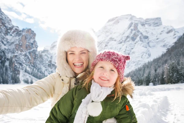 Madre e hijo tomando selfie frente a montañas nevadas — Foto de Stock