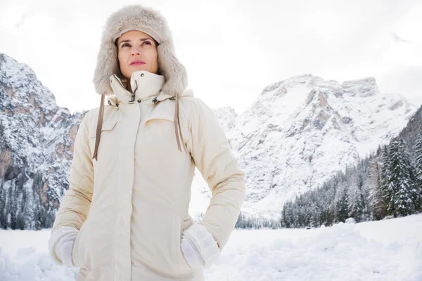 Frau in weißem Mantel und Pelzmütze steht im Winter draußen Stockfoto