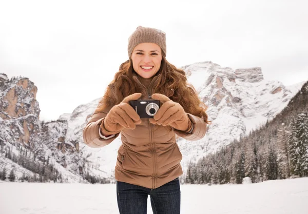 Mulher com câmera compacta ao ar livre entre montanhas cobertas de neve — Fotografia de Stock