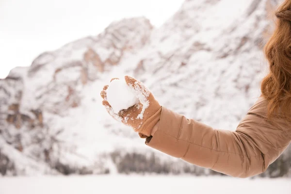 Closeup on throwing snowball woman among snow-capped mountains — Stock Photo, Image