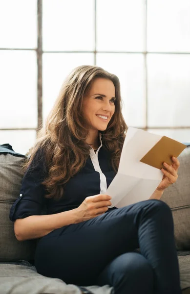 Sorrindo jovem mulher de cabelos castanhos segurando carta — Fotografia de Stock