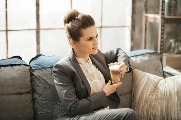 Young businesswoman is sitting on couch with cup of coffee — Φωτογραφία Αρχείου