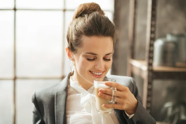 Smiling businesswoman enjoying cup of coffee latte macchiato — Stock Photo, Image