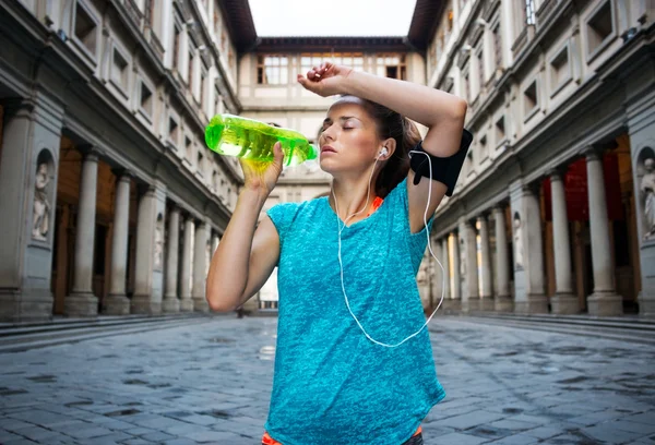 Fitness woman is drinking water while outdoors training — 스톡 사진