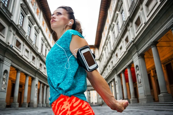 Young female in sports outfit next to Uffizi gallery in Florence — Stock fotografie