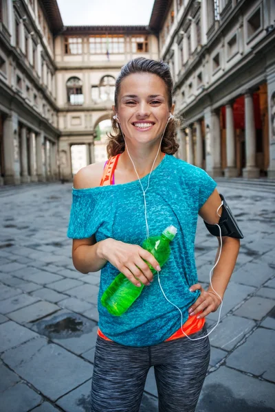 Молодая улыбающаяся спортивная женщина с бутылкой воды. Флоренция — стоковое фото