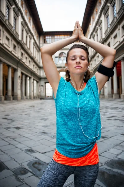 Mujer joven fitness con auriculares haciendo yoga al aire libre. Florencia —  Fotos de Stock