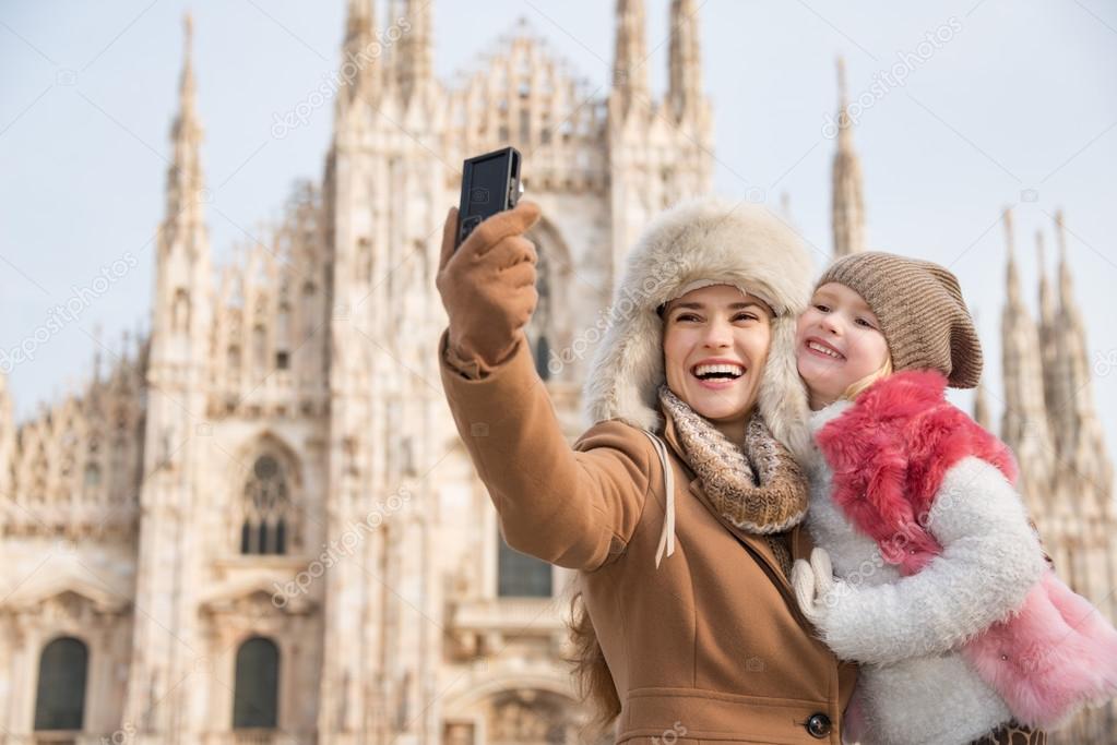 Happy mother and daughter taking selfie in front of Duomo, Milan