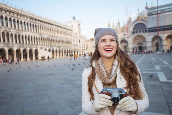 Mujer sosteniendo cámara fotográfica en Piazza San Marco y mirando hacia arriba —  Fotos de Stock