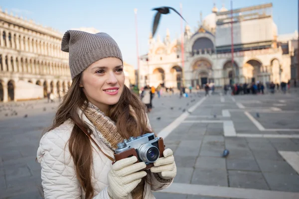 Young woman holding retro photo camera on Piazza San Marco — Stockfoto