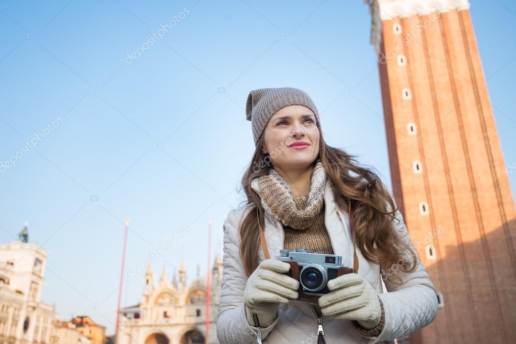 Pensive woman holding camera in front of Campanile di San Marco Stock Photo  by ©CITAlliance 98967944