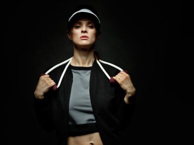 Direniş band siyah arka planda tutan kadın atlet