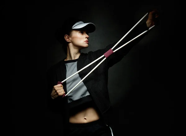 Fit vrouw training met weerstand band tegen zwarte achtergrond — Stockfoto