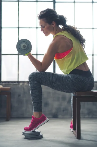 Emelő súlyzó loft edzőteremben fitness nő — Stock Fotó