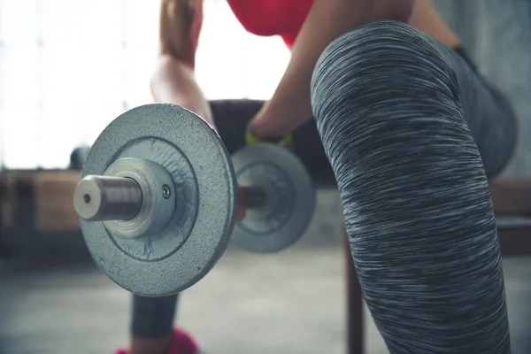 Close-up op fitness vrouw houdt van halter in loft sportschool — Stockfoto