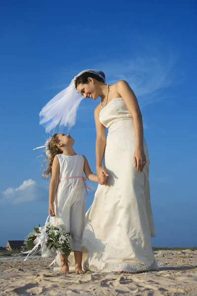 Sposa e ragazza dei fiori sulla spiaggia — Foto Stock