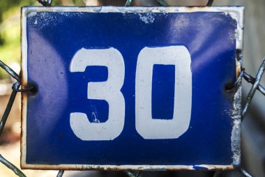 Yıpranmış, köhne, metal plakalı, 30 numaralı sokak adresi.