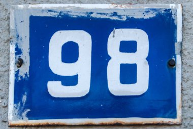 Yıpranmış, köhne, metal plakalı, 98 numaralı sokak adresi.
