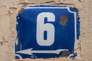 Yıpranmış kare metal plakalı sokak adresi numarası 6.